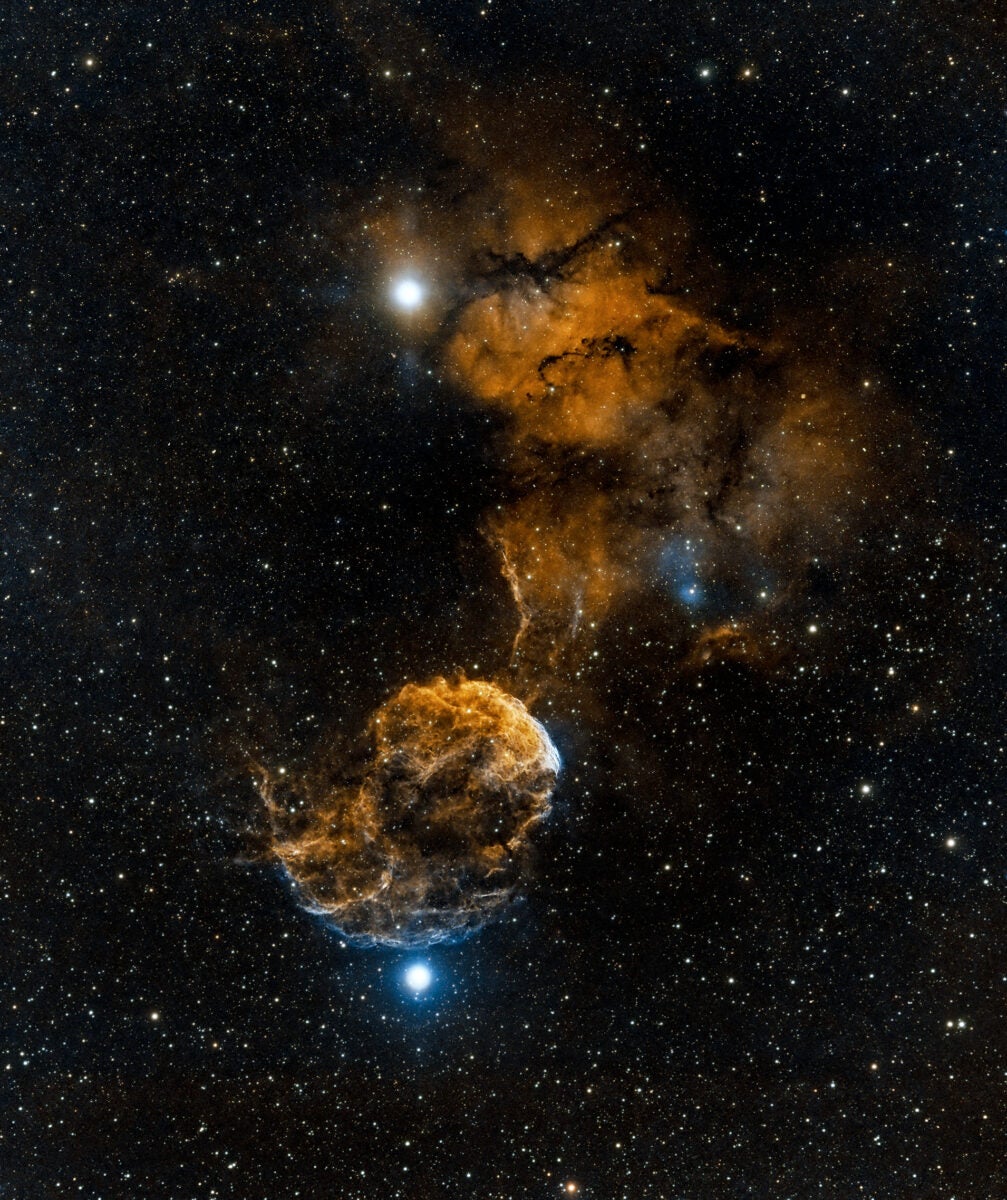 Located 5,000 light-years away in the constellation Gemini is a supernova remnant called the Jellyfish Nebula (IC 443). The two exceptionally bright stars in this wide-field telescopic view are Tejat (top) and Propus (bottom).